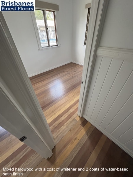 Mixed hardwood with a coat of whitener and 2 coats of water-based satin finish